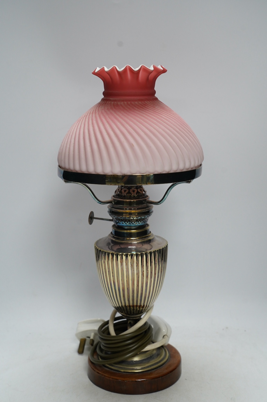 A silver plated table lamp, with a pink satin glass wrythen fluted shade, 41cm high. Condition - shade cracked, lamp untested